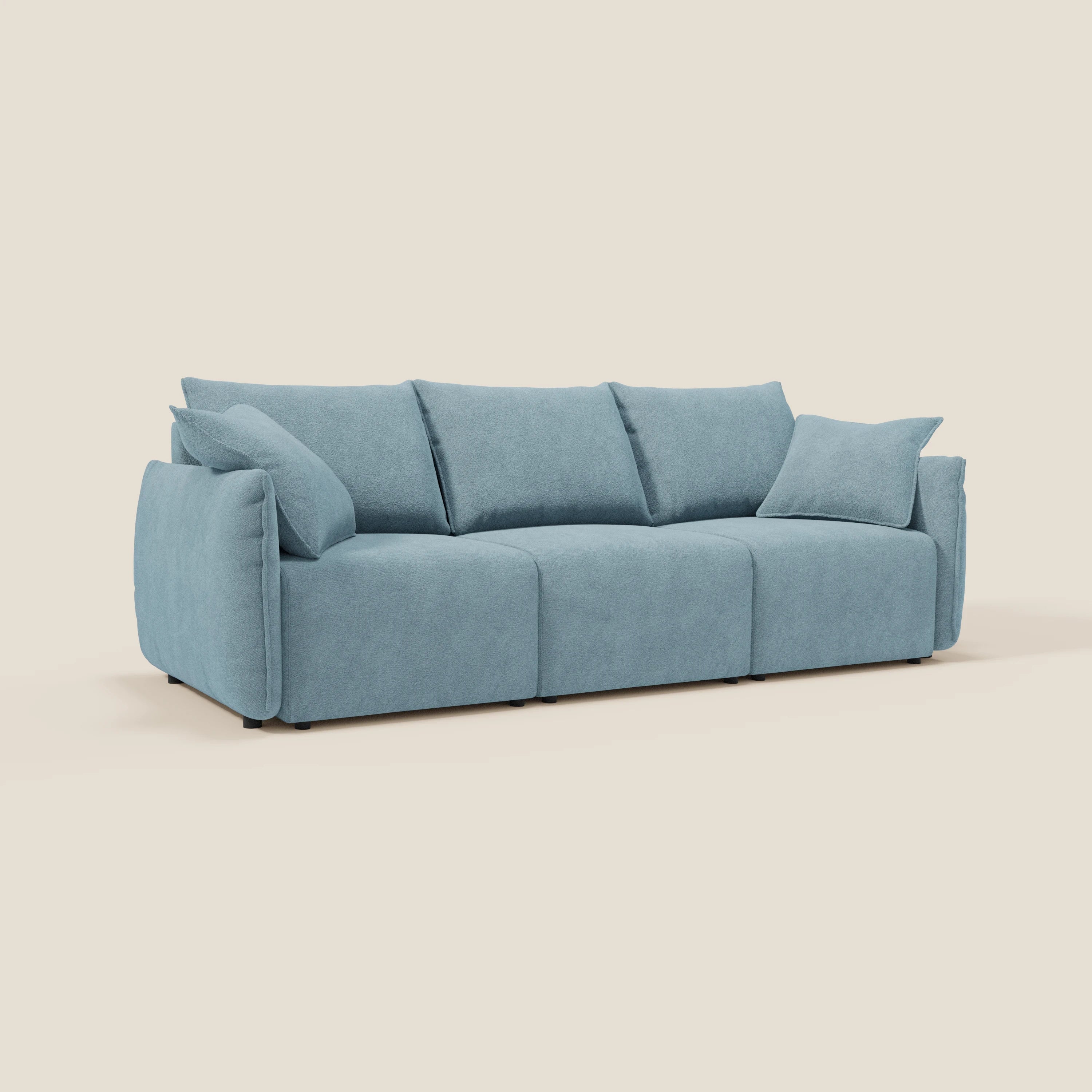 Divano moderno Flexar di Divani.Store in bouclé azzurro T07 carta da zucchero, con 3 sedute allungabili, schienale in piuma d'oca e cuscini in feltro con braccioli leggermente angolati, presentato su uno sfondo bianco sporco.