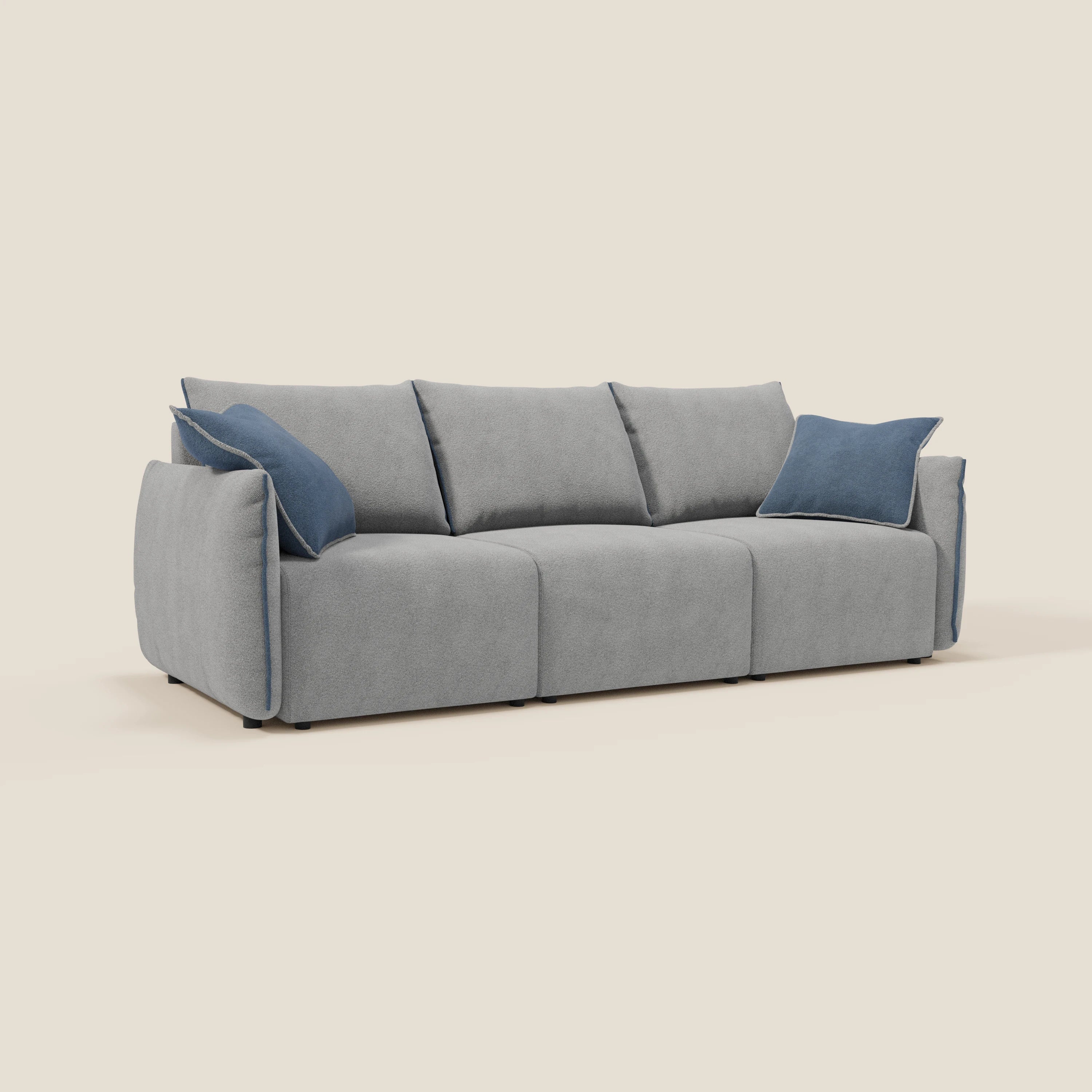 Il divano Flexar di Divani.Store è dotato di 3 sedute allungabili, schienale con imbottitura in piuma d'oca ed è disponibile in bouclé impermeabile T07 grigio-blu. Include ampi braccioli e cuscini d'accento blu, esposti su un semplice sfondo bianco sporco.