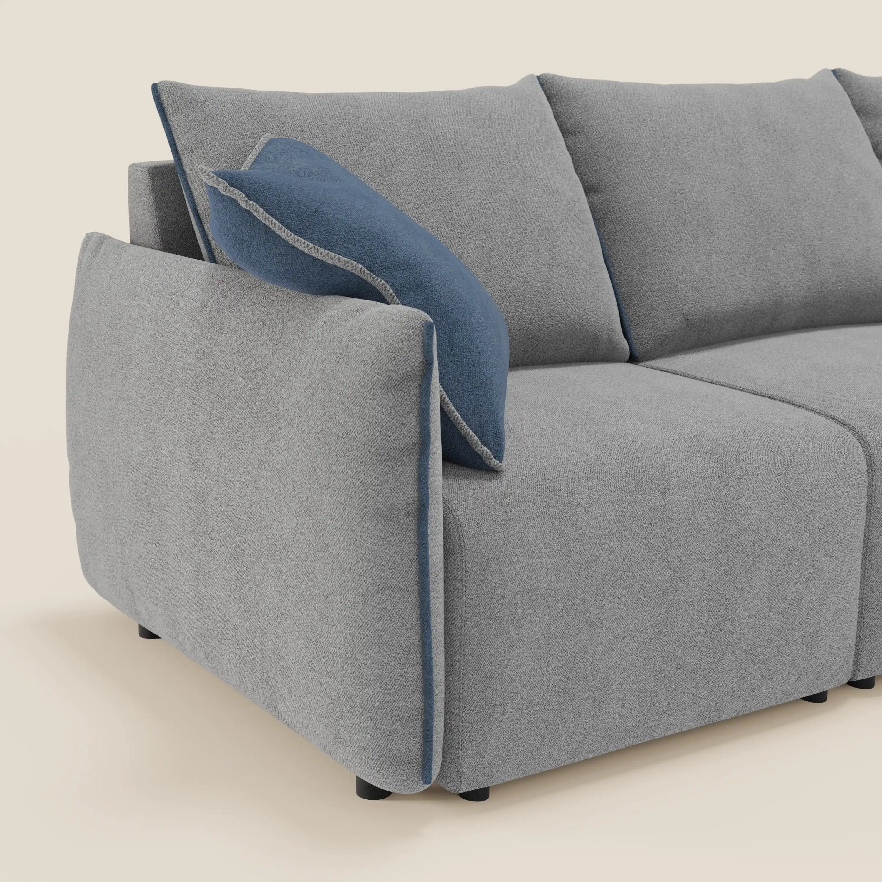 Il divano Flexar di Divani.Store è dotato di 3 sedute allungabili, schienali in piuma d'oca e rivestimento in bouclé T07 grigio impermeabile con accenti blu. I suoi cuscini morbidi e i braccioli arrotondati offrono un comfort personalizzabile su uno sfondo beige semplice.