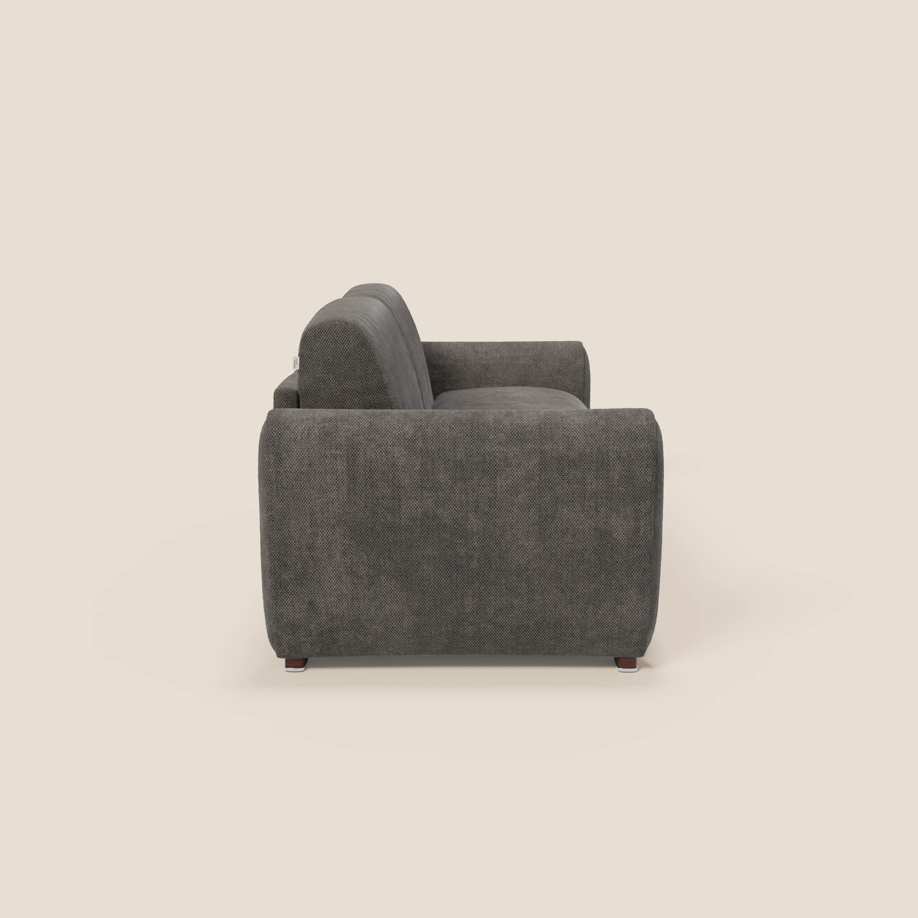 Il divano letto moderno Kaleo di Divani.Store, in raffinato tessuto impermeabile T26 antracite, è caratterizzato da uno spesso bracciolo, da una seduta imbottita con materasso H17 cm ad alta densità e da un semplice design squadrato visto lateralmente.