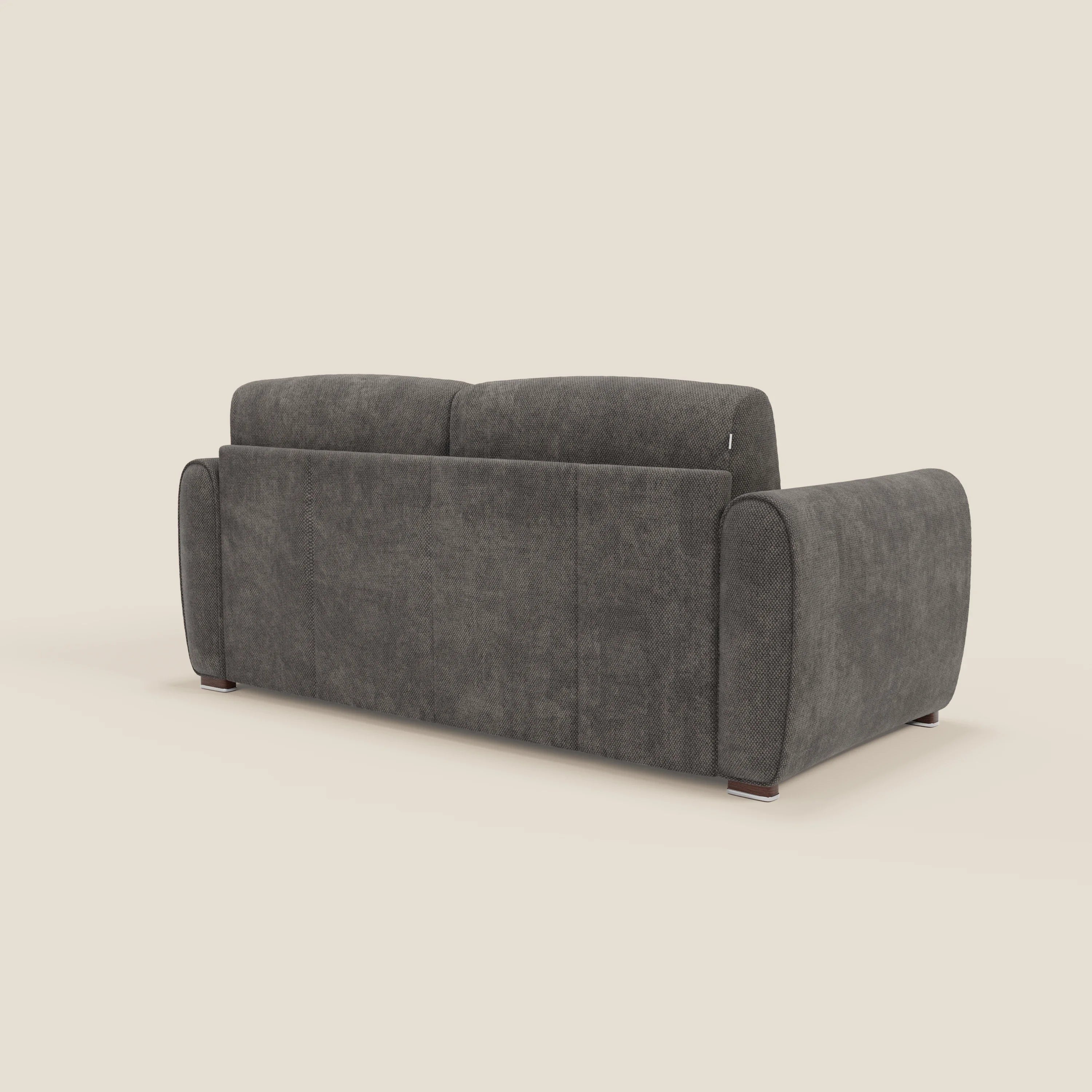Il divano letto moderno Kaleo di Divani.Store, visto da dietro in posizione angolata, è caratterizzato da ampi braccioli arrotondati, due cuscini in tessuto felpato con materasso ad alta densità da 17 cm e gambe corte in legno scuro in tessuto T26 antracite.