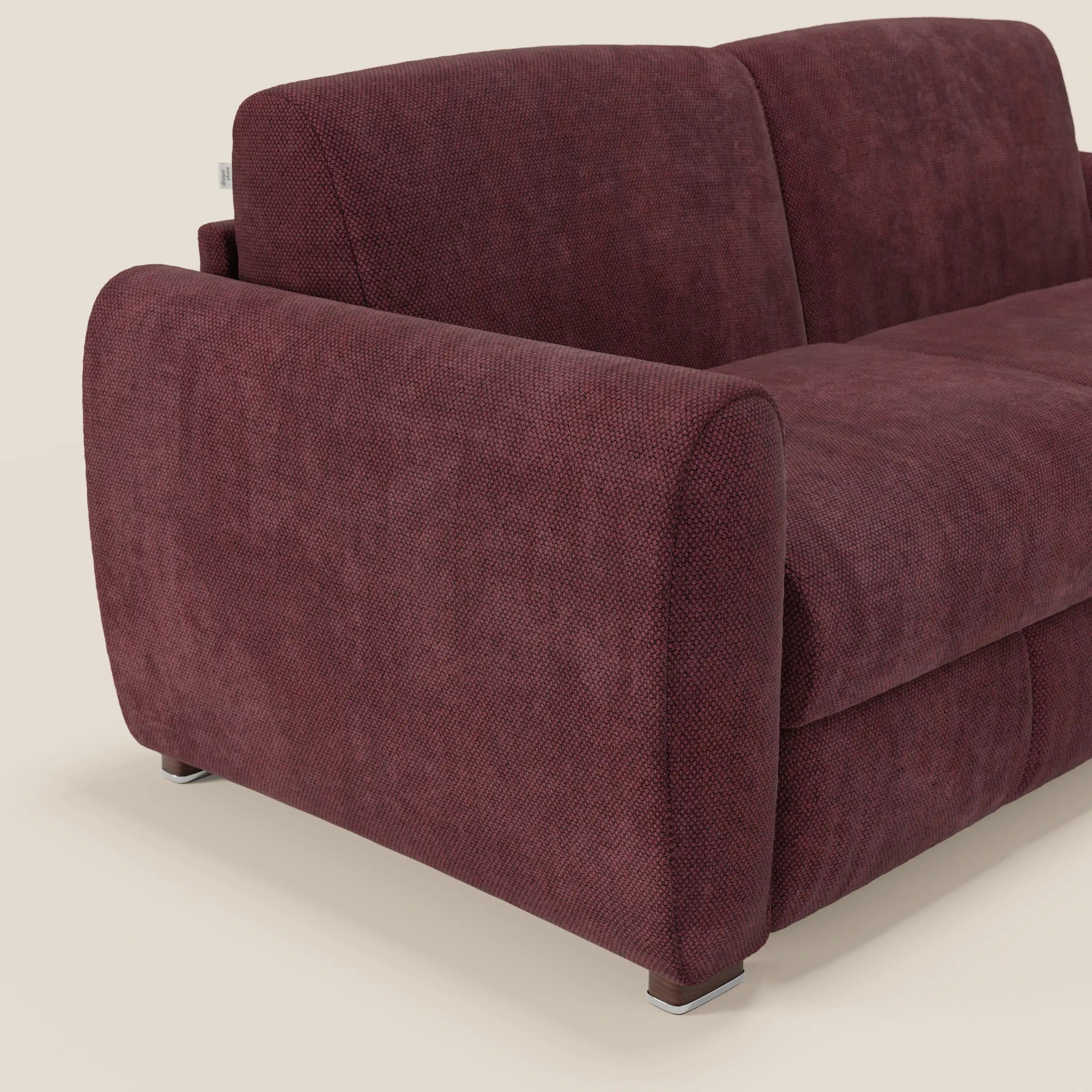 Il divano letto moderno Kaleo di Divani.Store, in tessuto impermeabile T26 prugna bordeaux, è caratterizzato da ampi braccioli arrotondati, sedute in materasso di H17 cm e gambe corte in metallo.