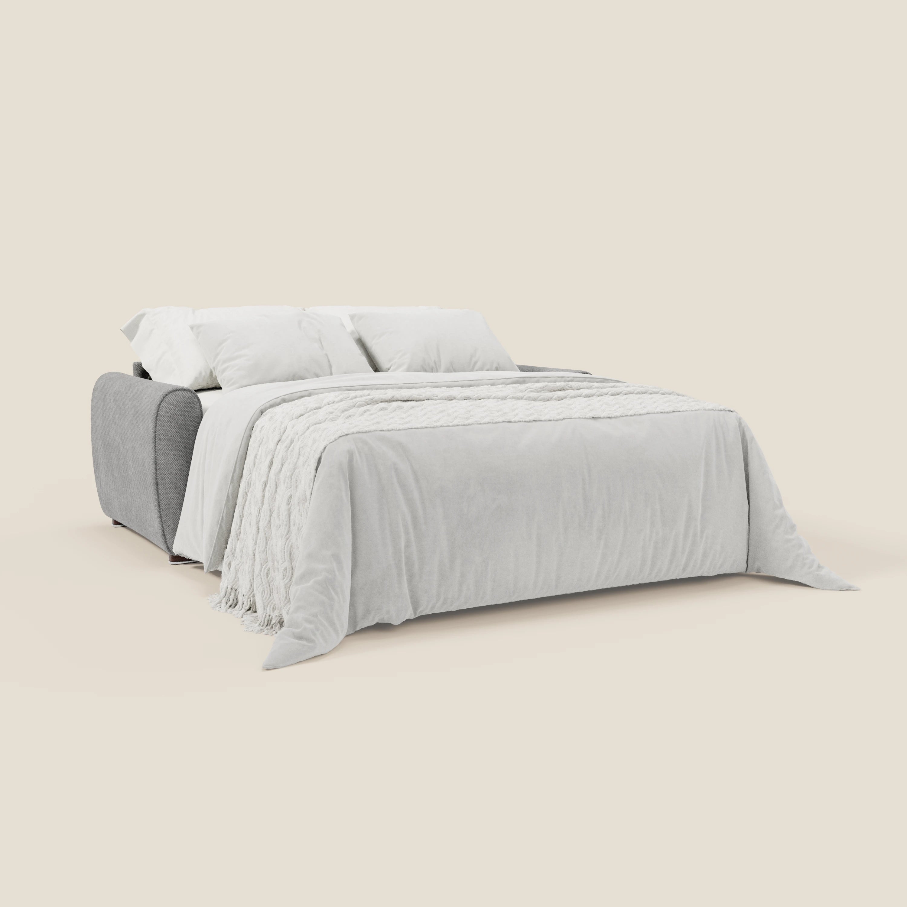 Il Kaleo Divano letto moderno con materasso H17 cm in tessuto impermeabile T26 grigio di Divani.Store è esteso a letto, coperto da una coperta grigia chiara e plaid, con due cuscini bianchi. Lo sfondo beige esalta il suo stile moderno ed essenziale.