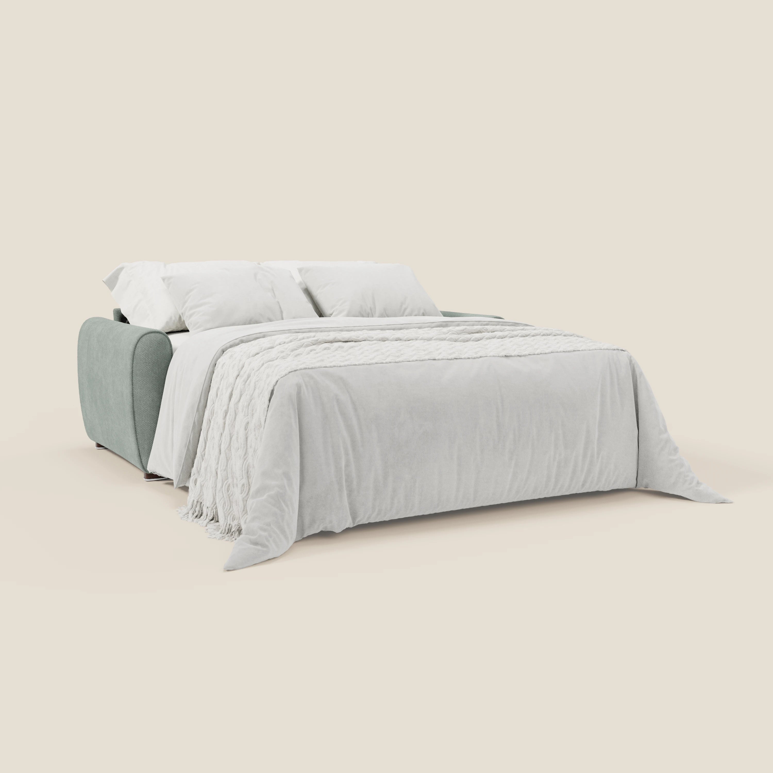 Il divano letto moderno Kaleo di Divani.Store in impermeabile T26 verde acqua si dispiega in un letto, sormontato da una coperta di peluche bianca, due cuscini bianchi e una coperta con frange, su uno sfondo beige.