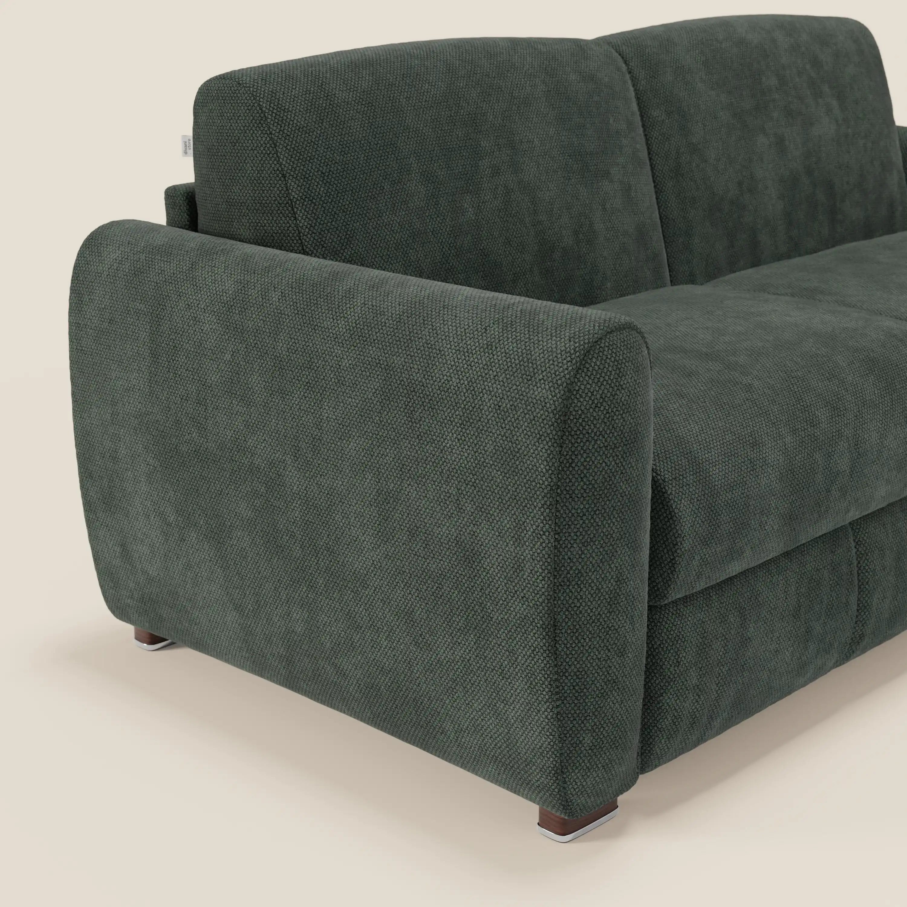 Primo piano del divano letto moderno Kaleo di Divani.Store, in raffinato tessuto impermeabile T26 verde oliva, con braccioli arrotondati, cuscini di seduta profondi con materasso H17 cm e gambe corte in legno su sfondo beige.