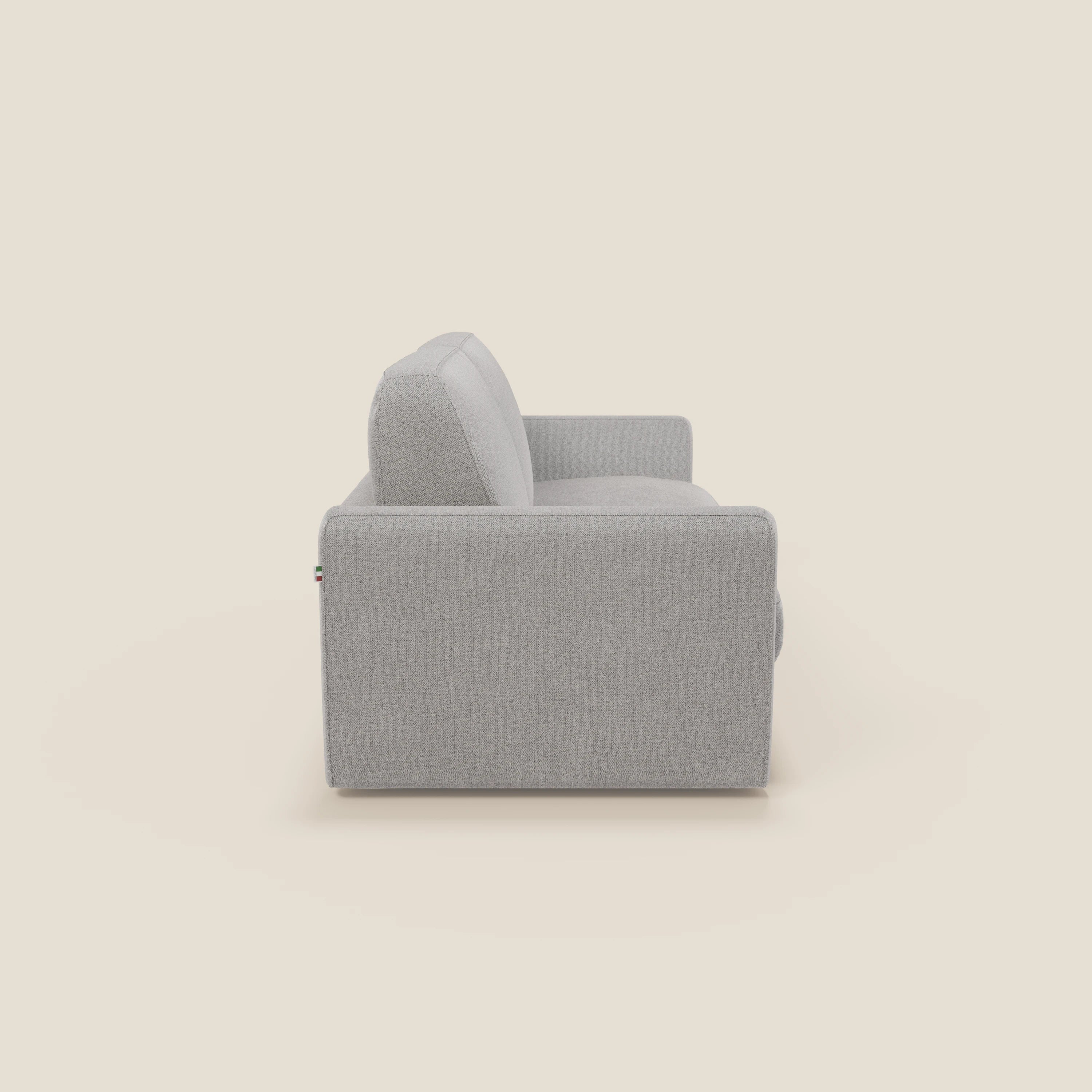 Vista laterale del divano letto sfoderabile Leonida di Divani.Store in tessuto T23 grigio smacchiabile, con braccioli quadrati e design minimale. Include un cuscino di seduta in peluche e un materasso alto H18 cm, su sfondo crema.