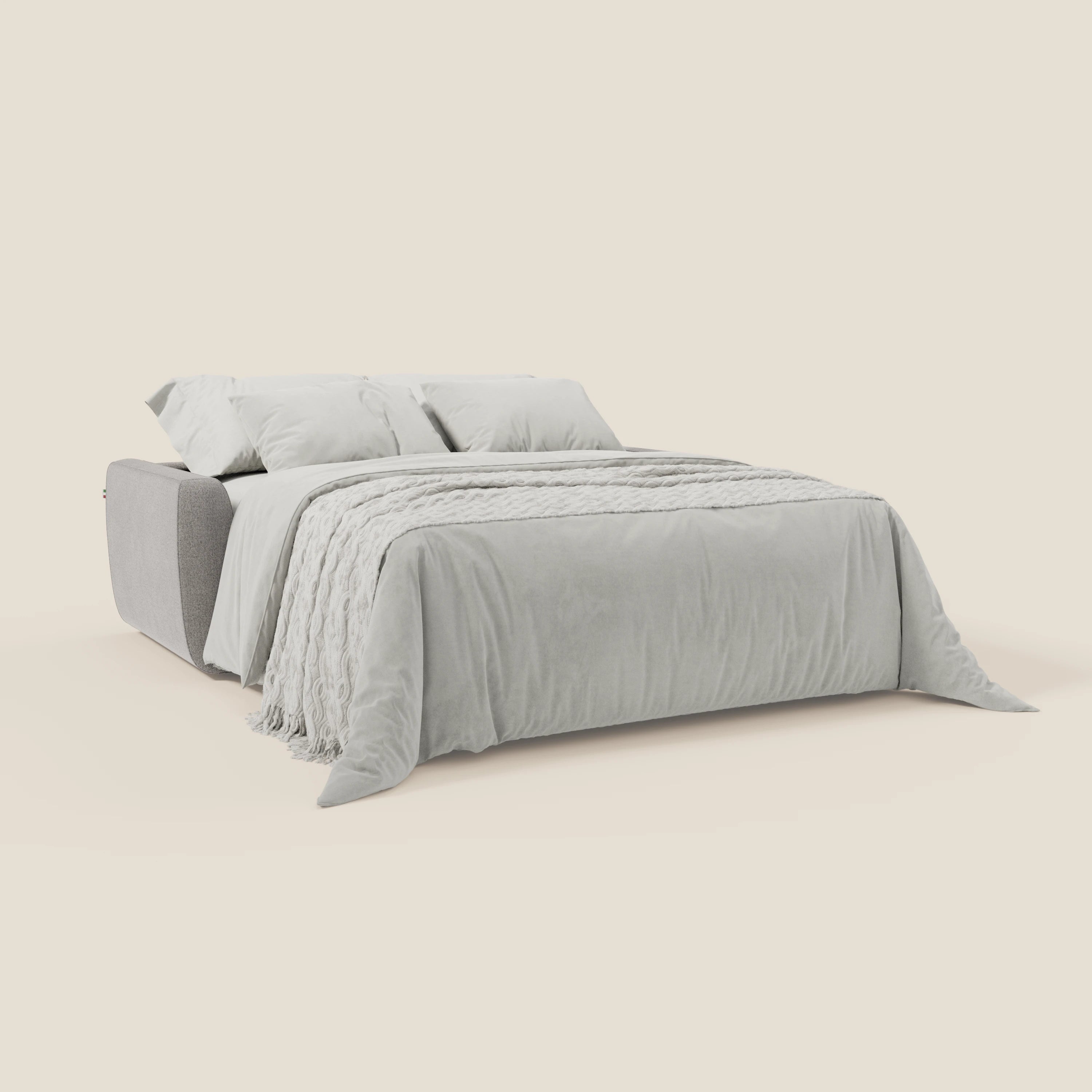 Il divano letto sfoderabile Leonida di Divani.Store, in tessuto smacchiabile T23 grigio con materasso H18 cm e vano porta guanciali, è caratterizzato da linee pulite e da un aspetto accogliente su uno sfondo tinta unita color crema.