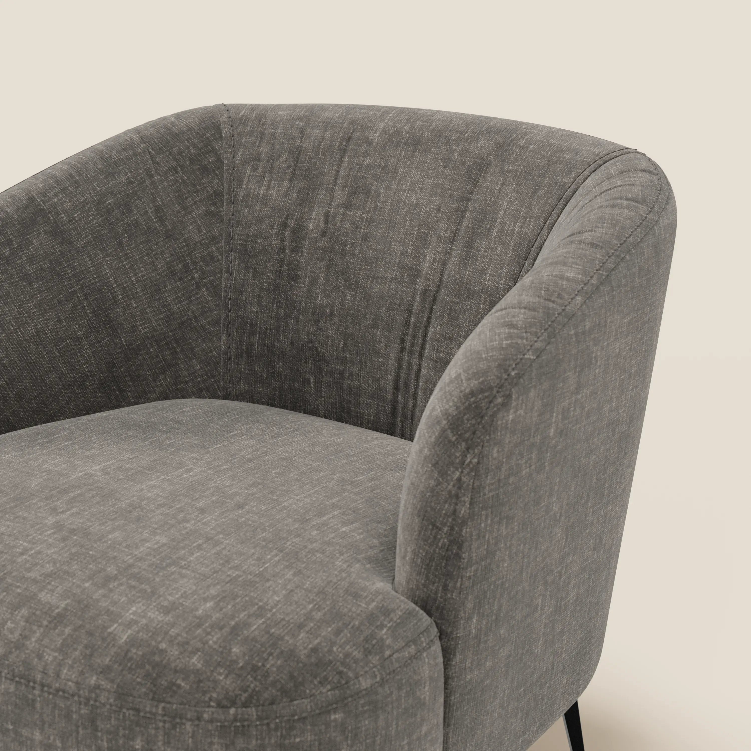 La poltroncina Renoa di Divani.Store presenta un design moderno in tessuto smacchiabile T24 antracite, uno schienale arrotondato e una texture morbida. Le gambe in metallo nero completano il look, sottolineando il comfort e l'eleganza contemporanea.