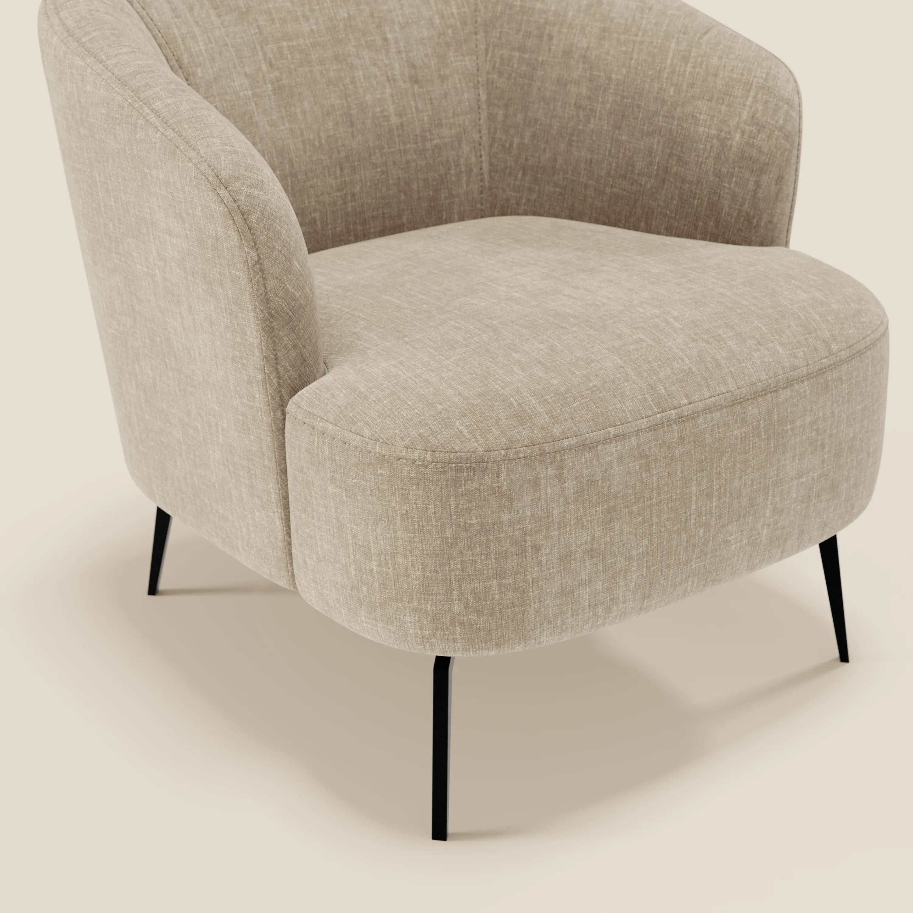 La poltroncina Renoa dall'eleganza moderna in tessuto smacchiabile T24 beige di Divani.Store è caratterizzata da un'imbottitura testurizzata, uno schienale curvo e sottili gambe in metallo nero, mostrate inclinate a destra su uno sfondo neutro per evidenziarne il design.