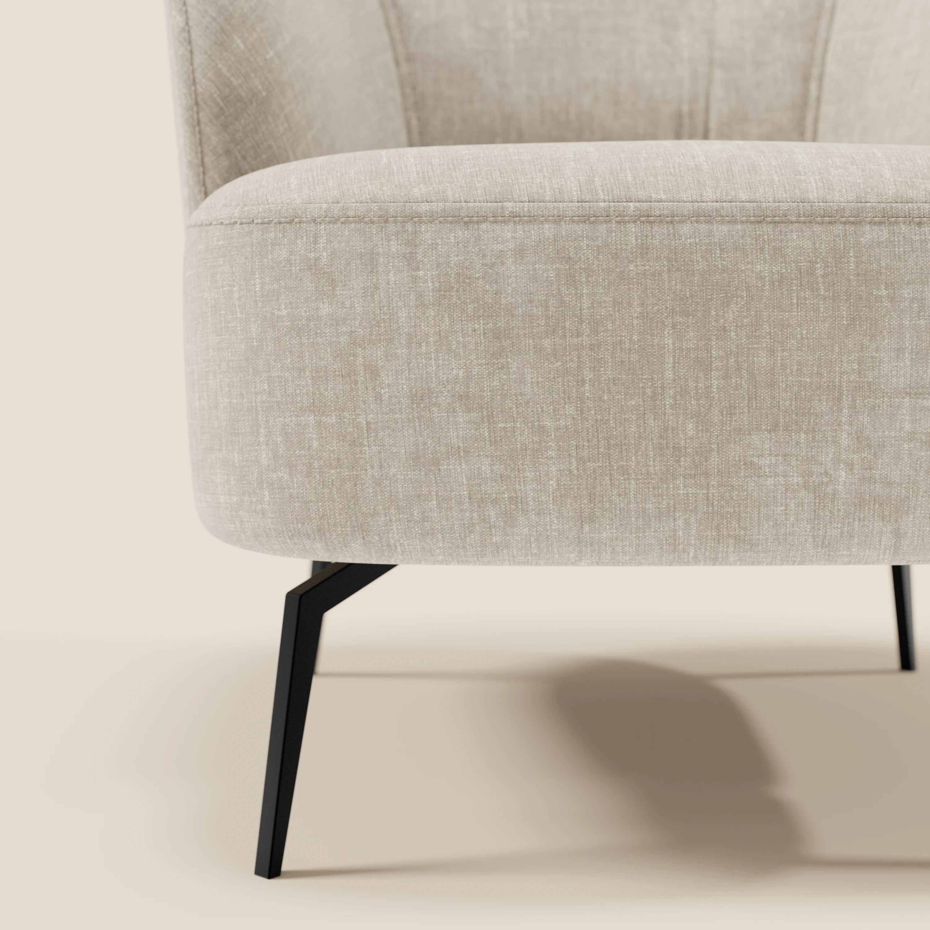 Primo piano della poltroncina Renoa dall'eleganza moderna di Divani.Store, rivestita in tessuto di lino chiaro T24, facile da pulire, con sottili gambe in metallo nero e uno schienale sottilmente curvato con dettagli verticali su uno sfondo neutro.