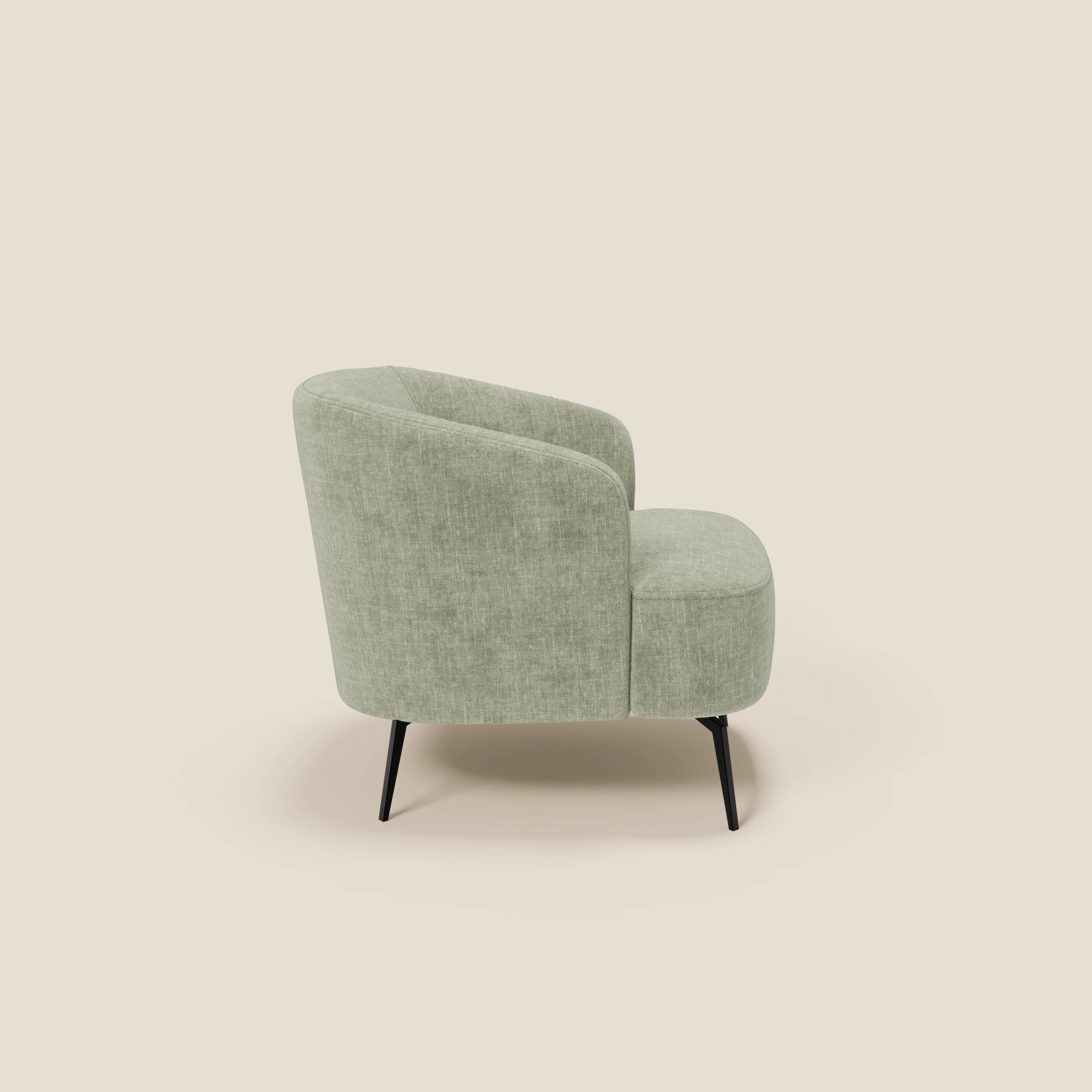 La poltroncina Renoa di Divani.Store, in tessuto smacchiabile T24 verde salvia, presenta uno schienale e una seduta curvi per un comfort avvolgente. Le sottili gambe in metallo nero esaltano il suo design moderno, presentato su un semplice sfondo beige.