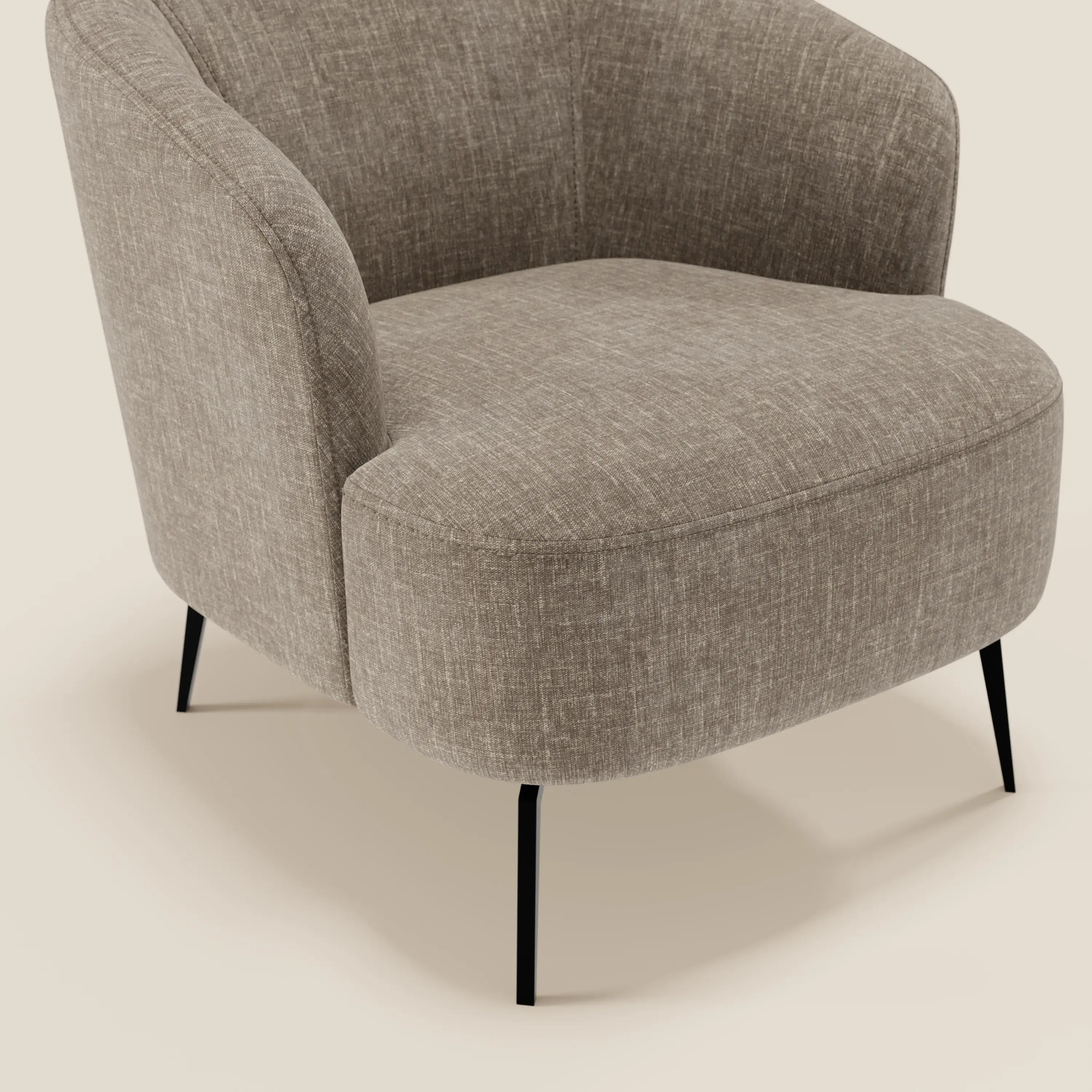 La poltroncina Renoa di Divani.Store, con schienale curvo, comfort ergonomico e sottili gambe nere, è rivestita in tessuto smacchiabile T24 marrone tortora, perfetto per ambienti moderni. In questo caso, lo sfondo è bianco sporco.