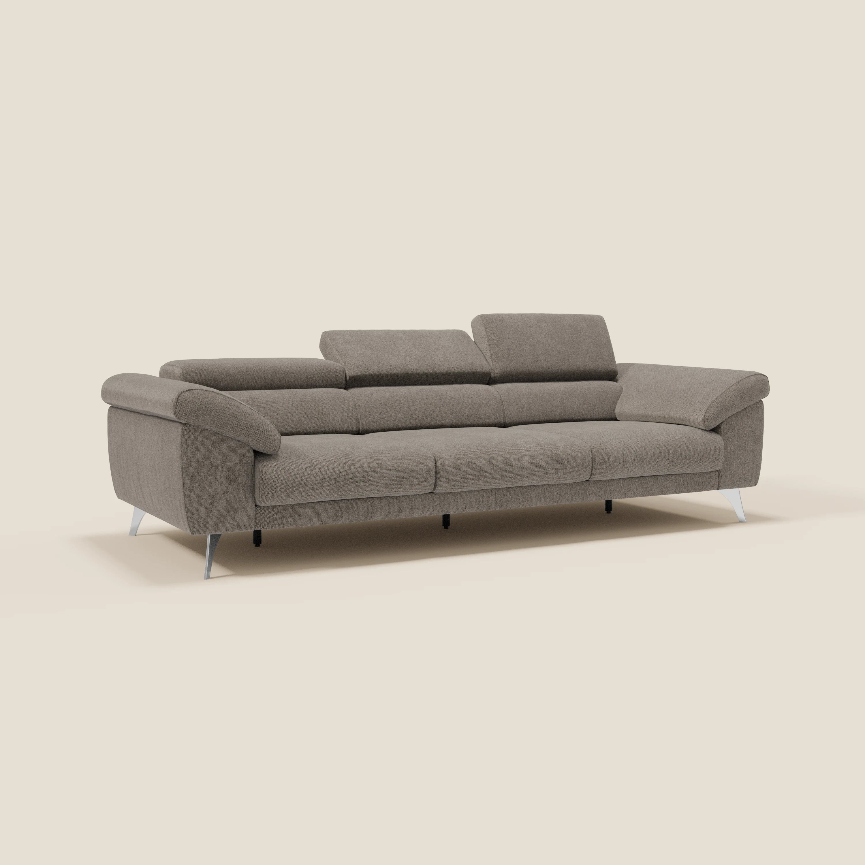 Il divano Donatello di Divani.Store, con 3 sedute allungabili, braccioli contenitore e poggiatesta reclinabili in tessuto smacchiabile T23 talpa, offre comfort contemporaneo e stile raffinato su uno sfondo beige neutro.