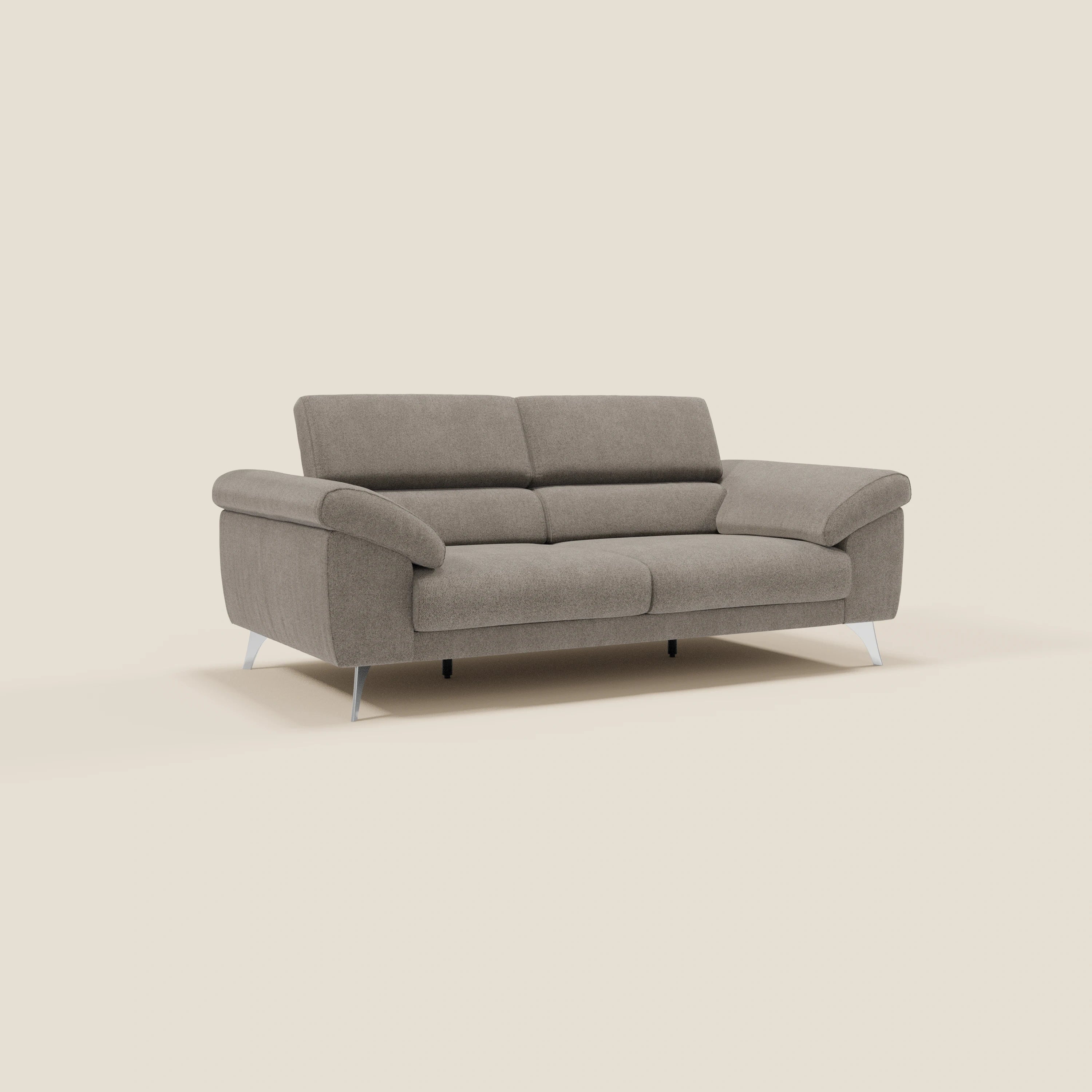 Divano contemporaneo Donatello di Divani.Store in tessuto smacchiabile T23 talpa, con sedute allungabili, braccioli contenitore e poggiatesta reclinabili. Il design moderno e il comfort intelligente si stagliano su uno sfondo color crema.