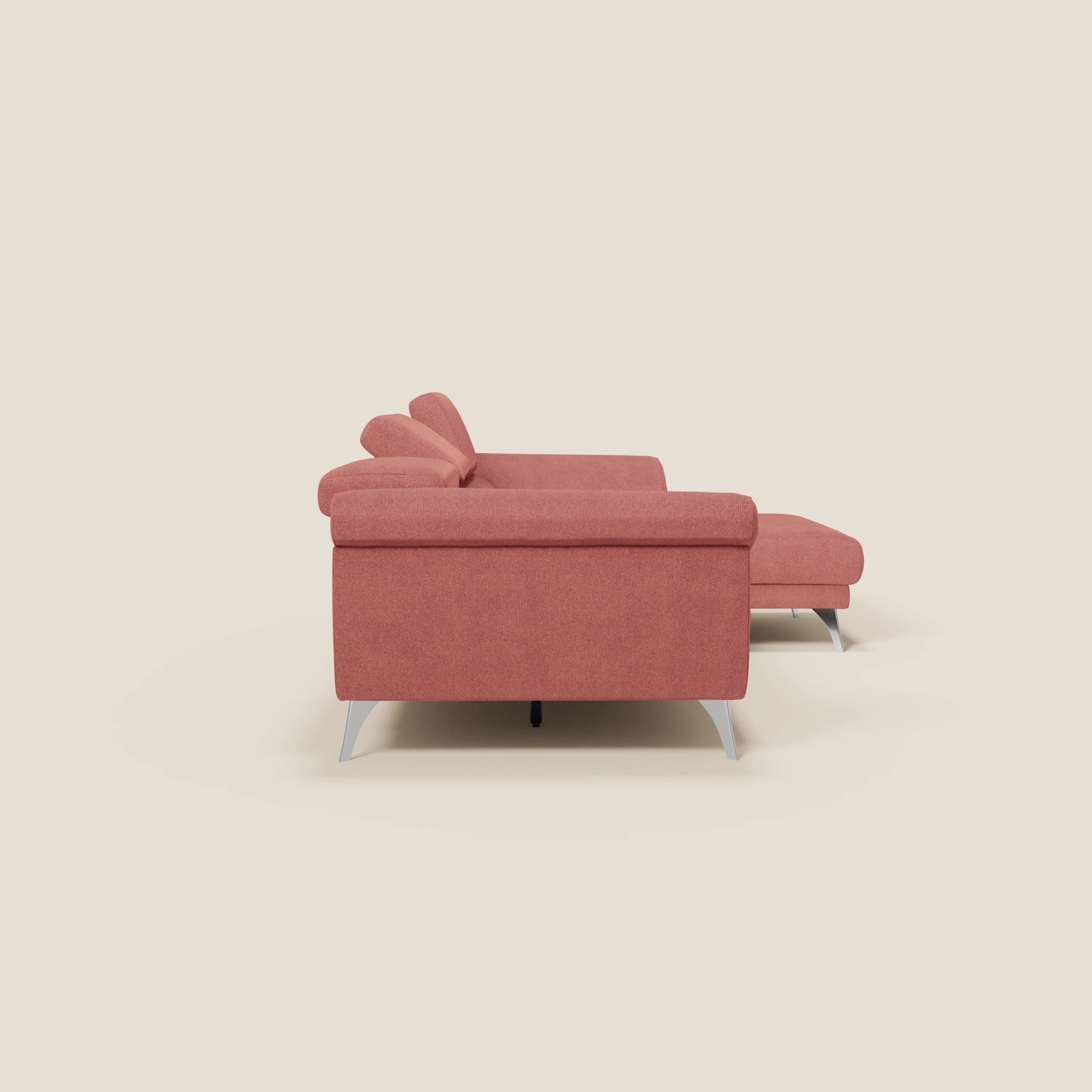 Vista laterale del Donatello Divano angolare di Divani.Store in T23 rosso ciliegia, con chaise lounge a destra, sedute scorrevoli, braccioli contenitori e poggiatesta regolabili. Su uno sfondo beige chiaro per un look contemporaneo.