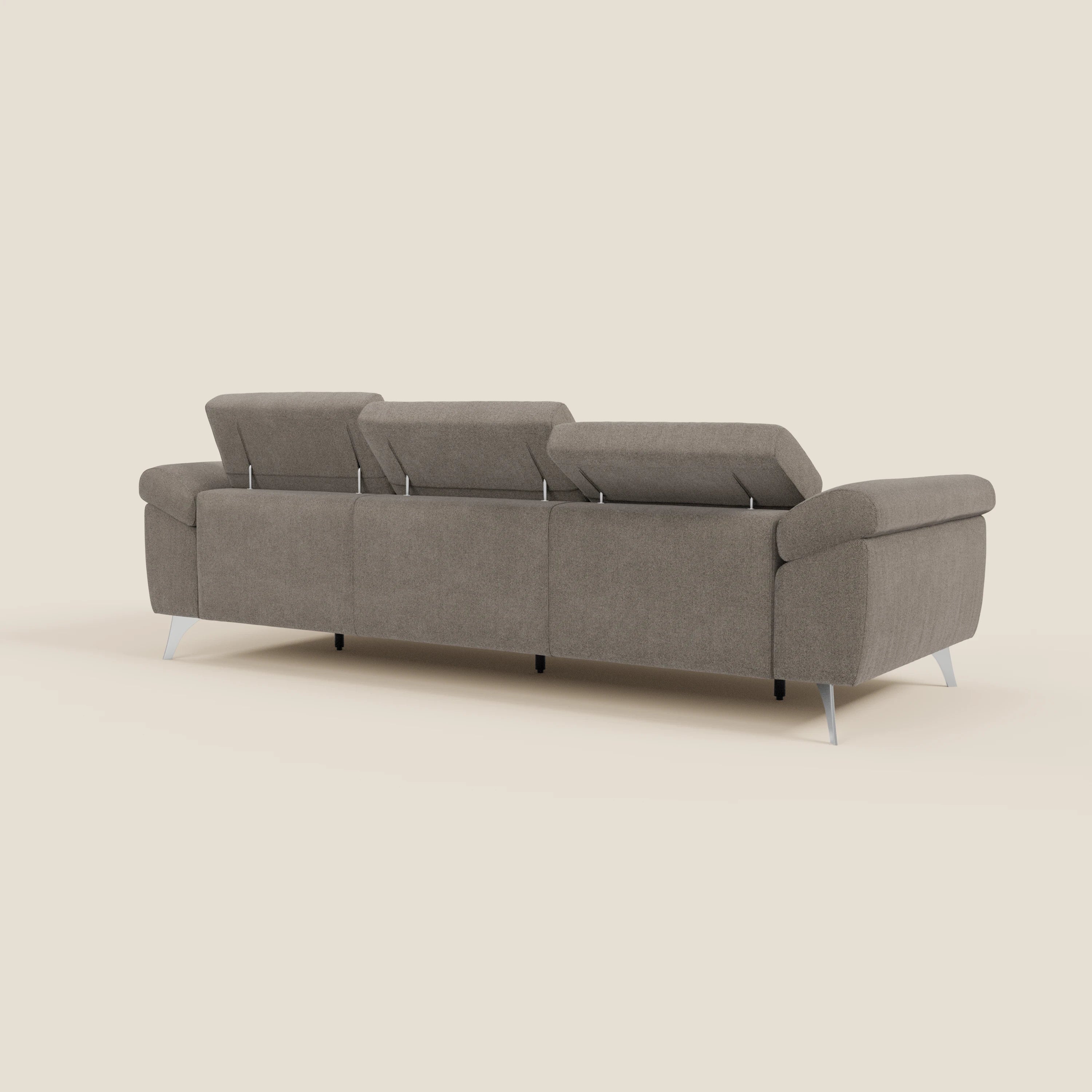 Il divano Donatello di Divani.Store, in tessuto smacchiabile T23 talpa, presenta 3 sedute allungabili, braccioli contenitore, poggiatesta reclinabili e gambe in metallo argentato su sfondo beige chiaro per un look contemporaneo.