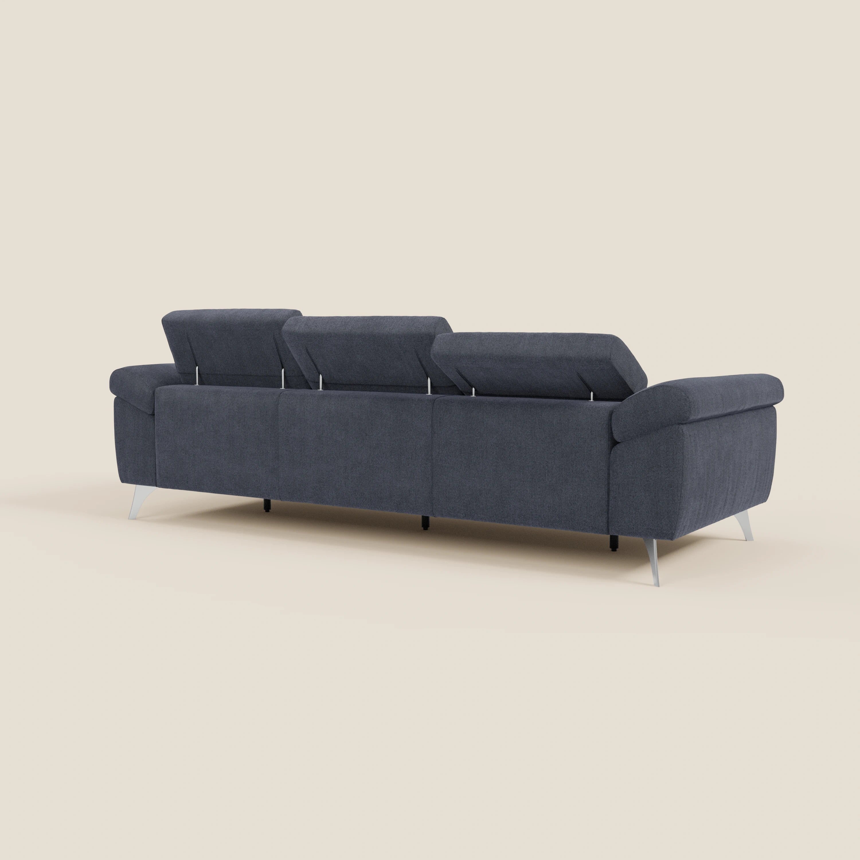 Il divano Donatello di Divani.Store in tessuto smacchiabile T23 blu ardesia è caratterizzato da 3 sedute allungabili, braccioli contenitore, poggiatesta reclinabili e linee pulite. Mostrato dal retro su uno sfondo beige semplice.