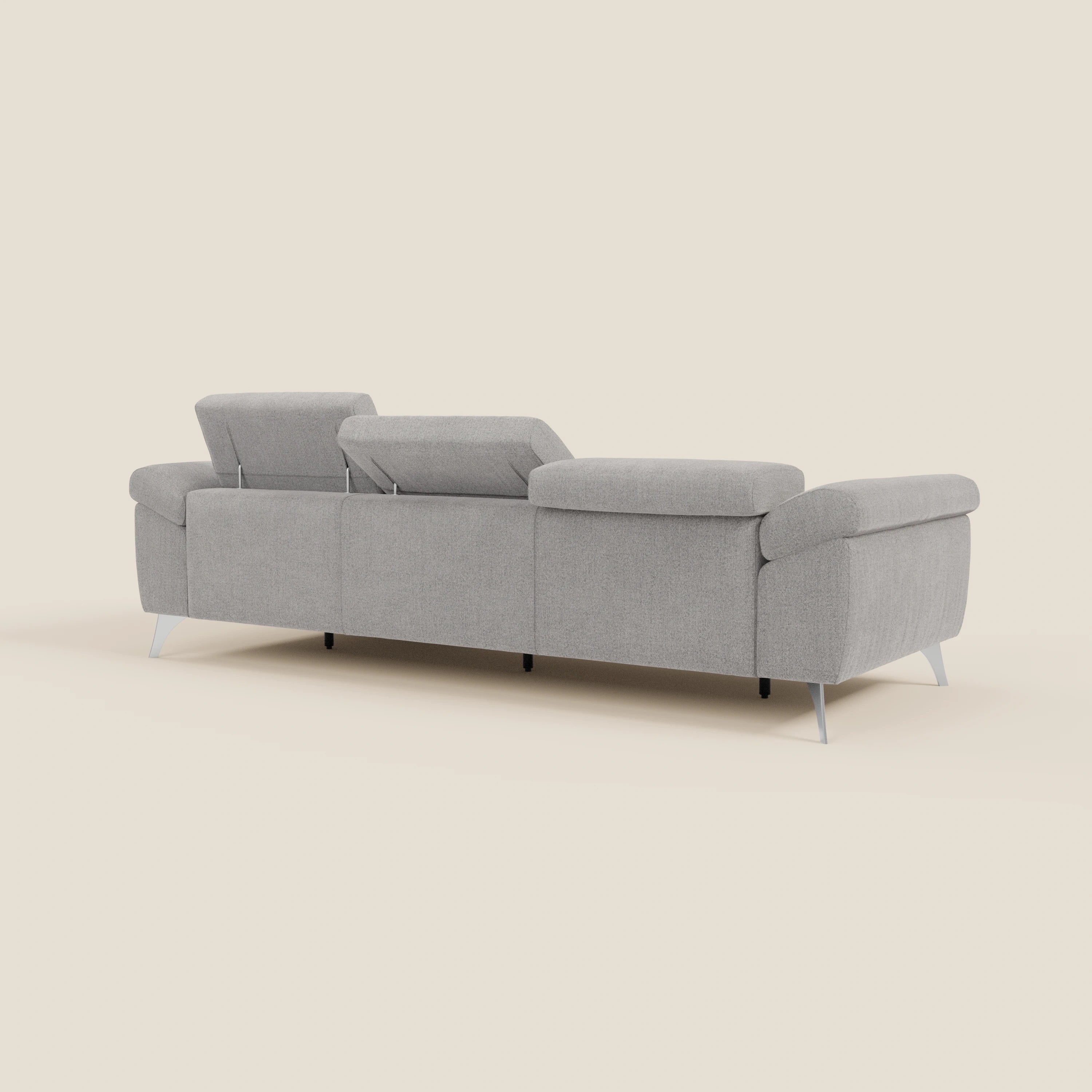 Un moderno Donatello Divano angolare T23 grigio chiaro di Divani.Store è mostrato dal retro, con tre poggiatesta regolabili, sedute scorrevoli, braccioli portaoggetti e sottili gambe angolari in metallo. Lo sfondo beige chiaro ne accentua le linee pulite e il design minimalista.
