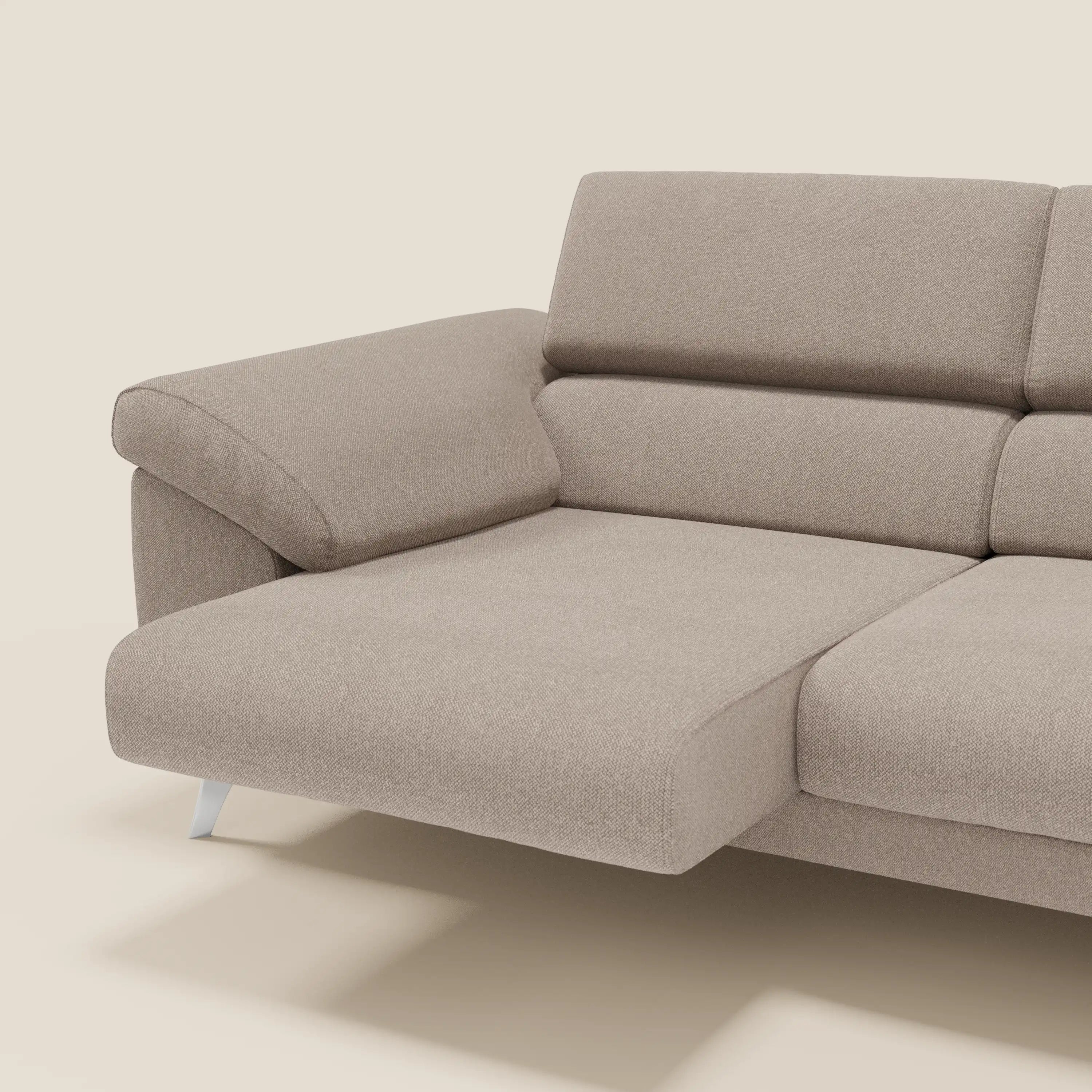 Il divano Donatello di Divani.Store è caratterizzato da sedute extra-profonde, braccioli con funzione di contenitore e poggiatesta reclinabili in tessuto antimacchia T23 taupe, con una chaise sul lato sinistro ed eleganti gambe in metallo argentato per un comfort moderno.