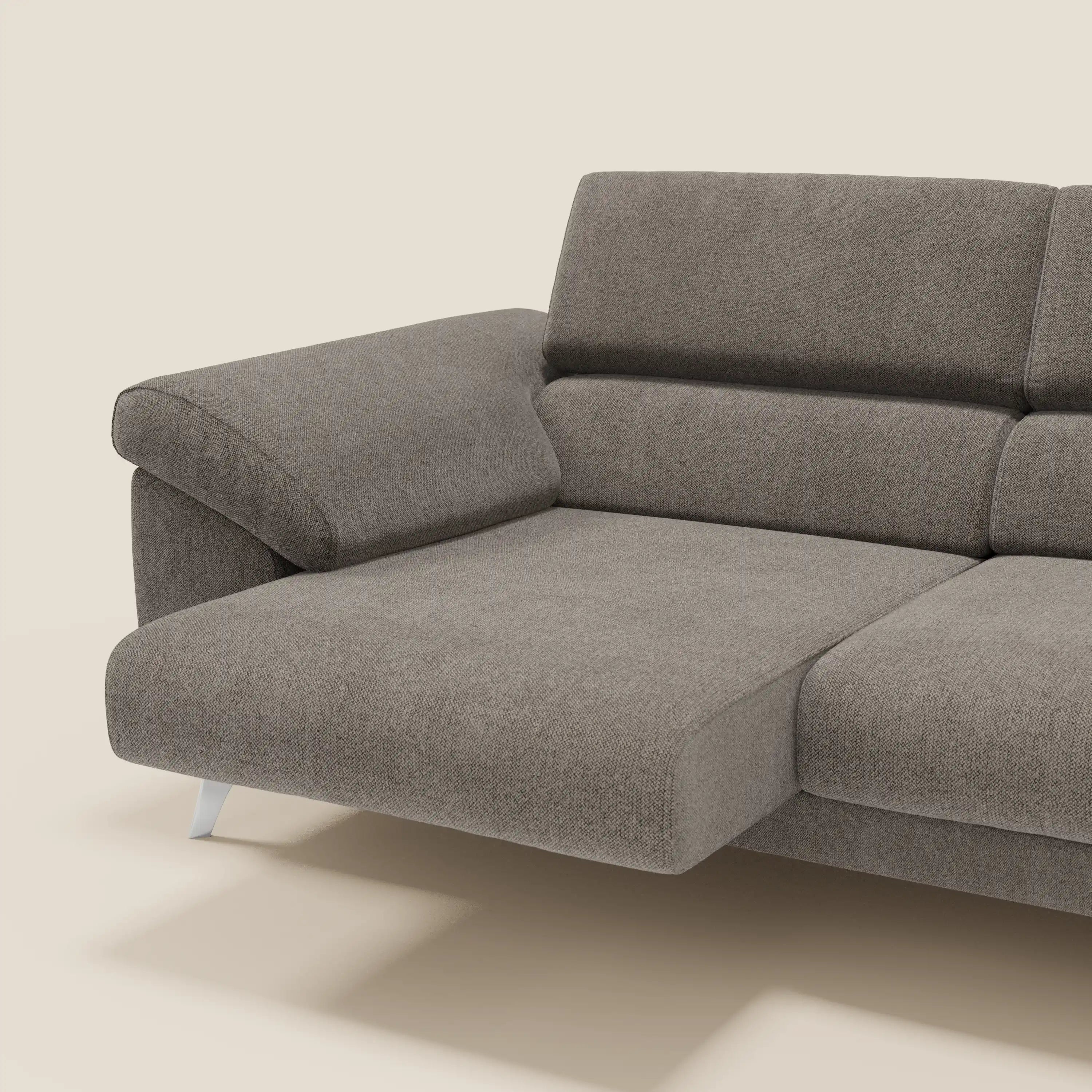 Il divano Donatello di Divani.Store è caratterizzato da 3 sedute estensibili, braccioli contenitori e poggiatesta regolabili in tessuto T23 taupe, facile da pulire, su uno sfondo beige chiaro.