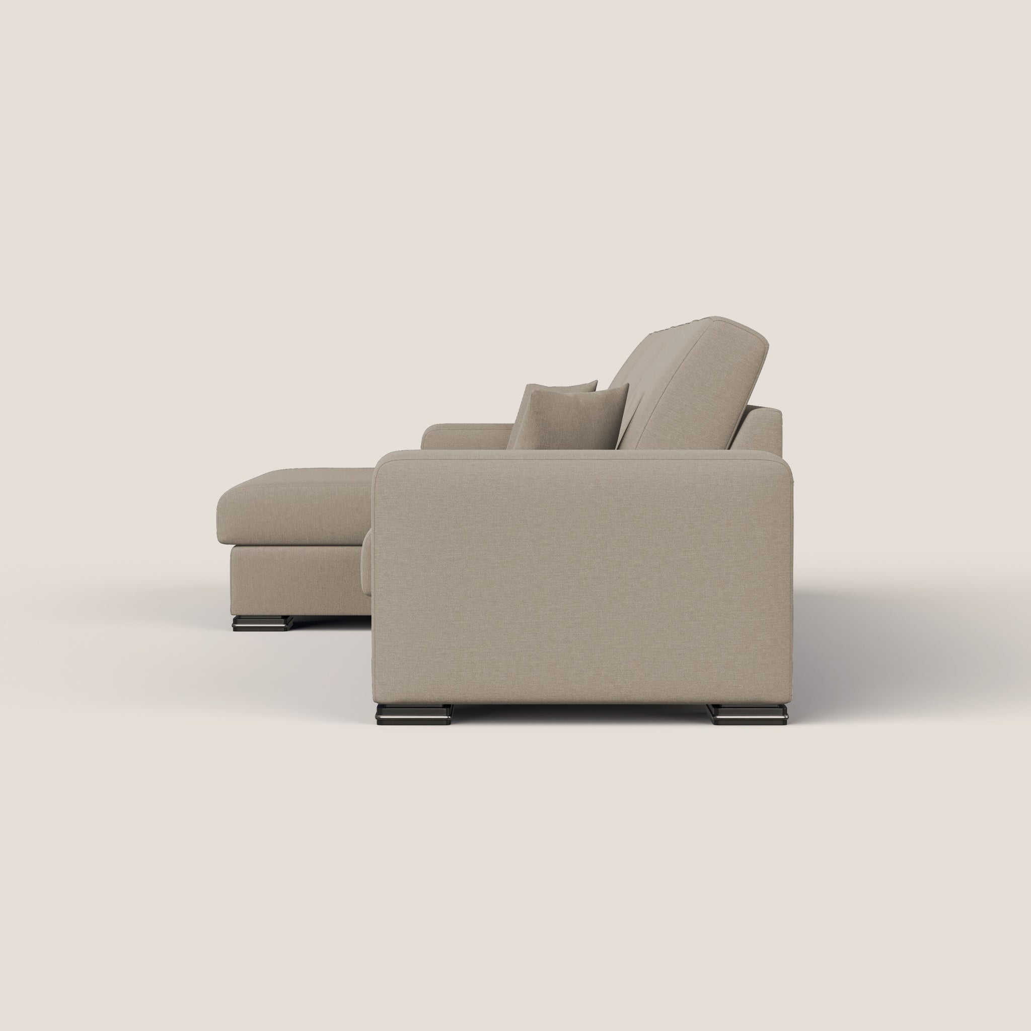 Vista laterale del GIOVE Divano angolare Sinistro 293 cm, un moderno divano beige di Homit | Italian Home Interiors, su uno sfondo bianco semplice. Questo divano a 5 posti presenta linee pulite con una chaise longue sulla sinistra, cuscini morbidi e gambe in metallo nero lucido. Il suo stile minimalista enfatizza comfort e funzionalità con tessuto impermeabile.